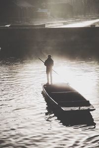 Rear view of man on boat at sunset
