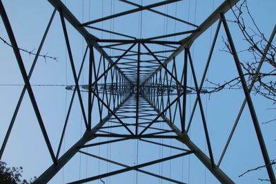 Low angle view of electricity pylon against clear sky