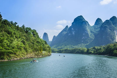 Scenic view of river and mountains against sky