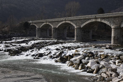 Arch bridge over river during winter