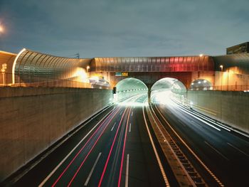 Light trails on road against sky at night