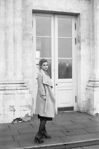 Portrait of woman standing on footpath