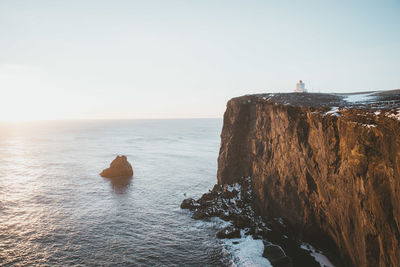 Rock formation in sea against sky