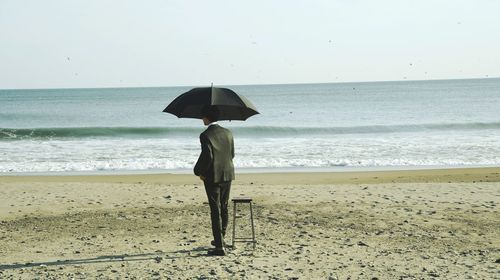 Rear view of woman standing on beach