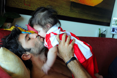 Father kissing daughter at home