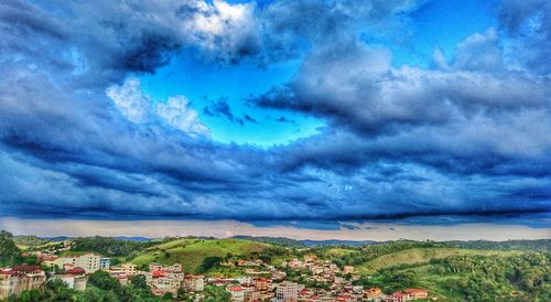 Silhouette of houses against cloudy sky