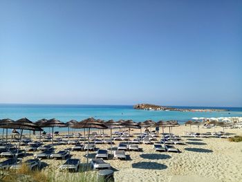 Scenic view of beach against clear blue sky