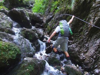 Low angle view of mid adult man climbing on mountain