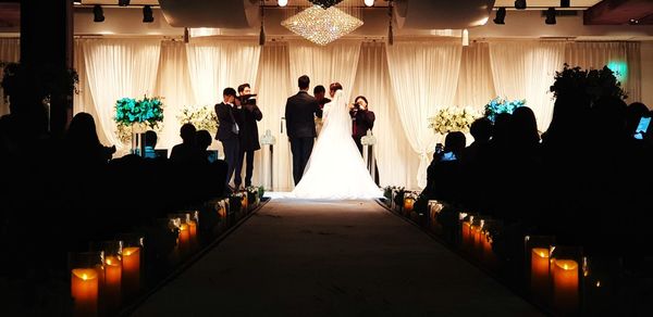 People standing by bride and groom during wedding