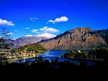 Scenic view of lake and mountains against blue sky