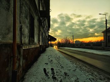 Railroad track against cloudy sky at sunset