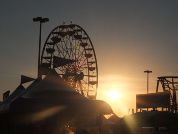 Low angle view of silhouette ferris wheel against sky during sunset