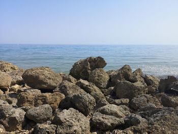 Rocks on shore against clear sky