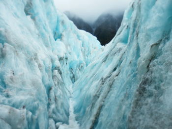 Close-up of snow on mountain against sky