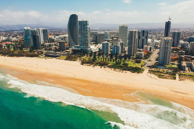 Aerial view of buildings in city against sky