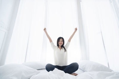 Full length of young woman lying on bed