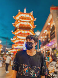 Portrait of young man standing in city chinatown 