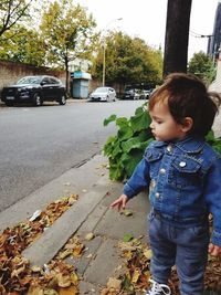 Boy standing on road in city