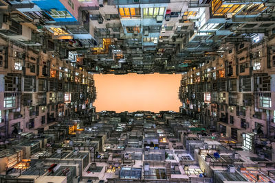 Directly below shot of buildings against sky at sunset