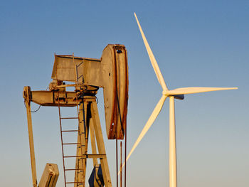 Low angle view of windmill against clear blue sky