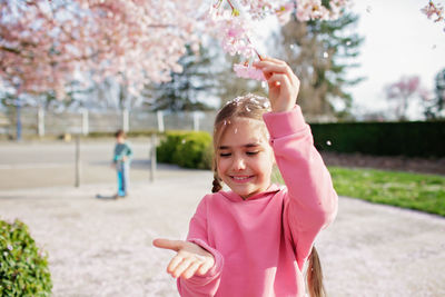 Portrait of cute girl blowing bubbles in park