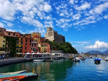 Sailboats moored on sea against buildings in city