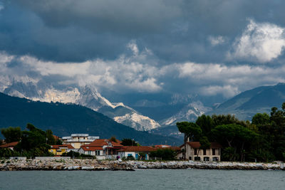 Scenic view of townscape by mountains against sky