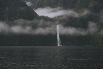 Scenic view of waterfall and mountains at milford sound, new zealand