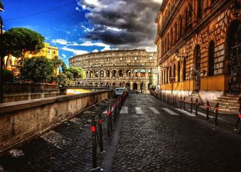 Street amidst buildings in city against sky at dusk