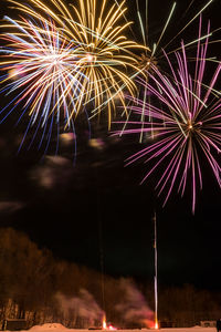 Low angle view of firework display at night