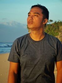 Mid adult man standing against sea