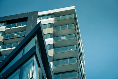 Low angle view of modern building against clear blue sky