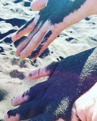 Close-up of hands on sand