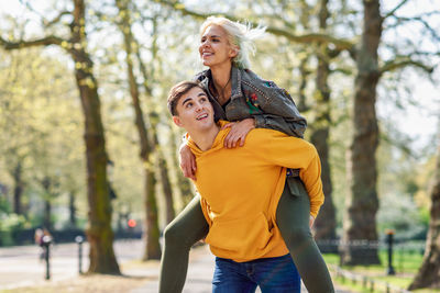 Man piggybacking woman at park