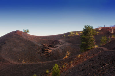 Scenic view of arid landscape against clear blue sky