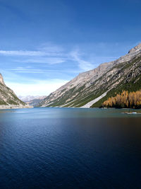 Scenic view of lake by mountains against sky