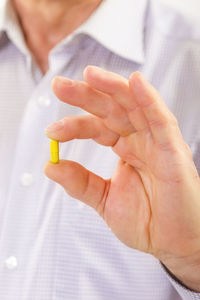 Midsection of man holding capsule