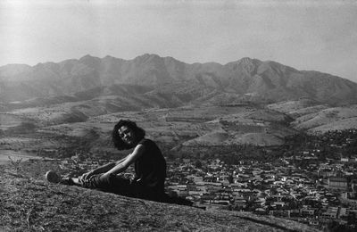 Rear view of woman sitting on mountain