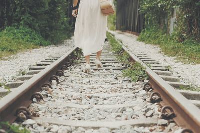 Woman walking on railroad tracks