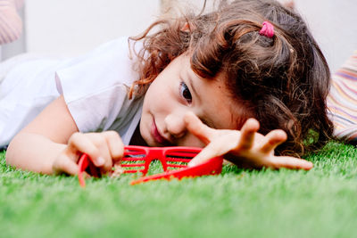 Girl playing with novelty glasses while lying on grass