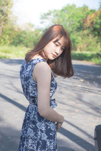 Smiling woman standing on road 