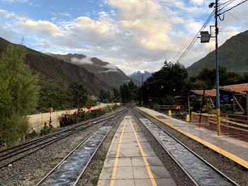 Railroad tracks in mountains against sky