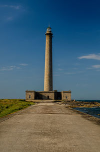 Lighthouse by sea against sky