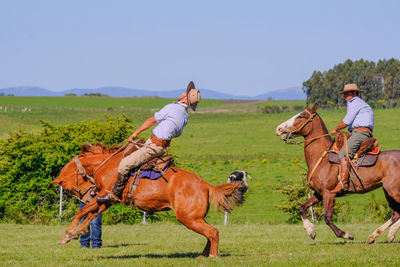 People riding horses on field