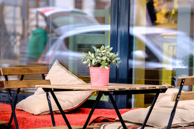 Close-up of empty chairs and table at sidewalk cafe