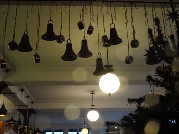 Low angle view of illuminated lamp hanging on ceiling