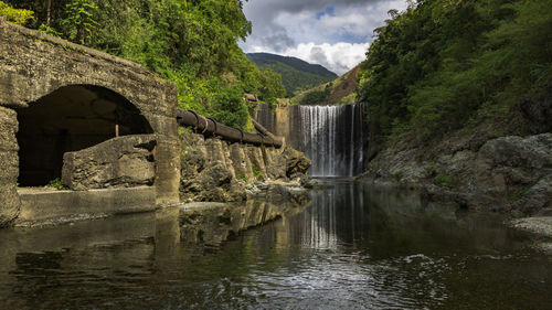Scenic view of waterfall against sky
