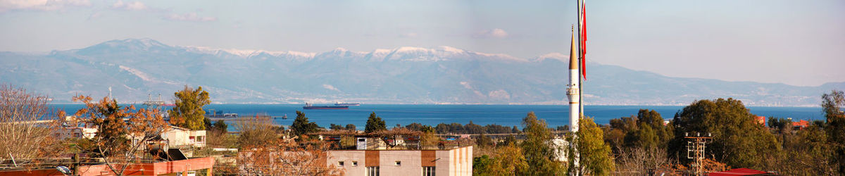 Panoramic view of townscape and mountains against sky