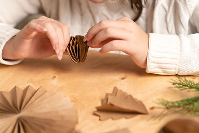 Midsection of woman holding christmas decorations on table