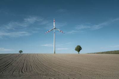 Windmill on field against sky